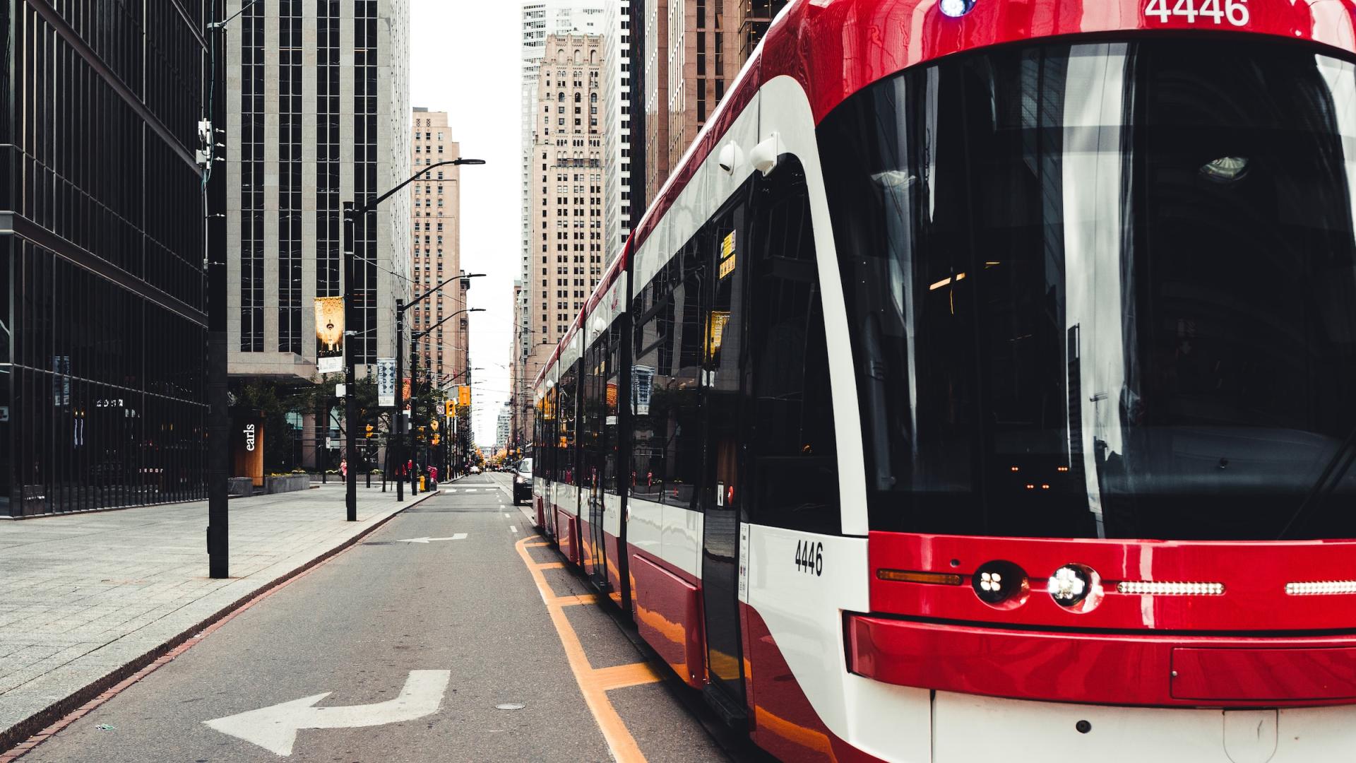A downtown scene with a train in the middle of a major road